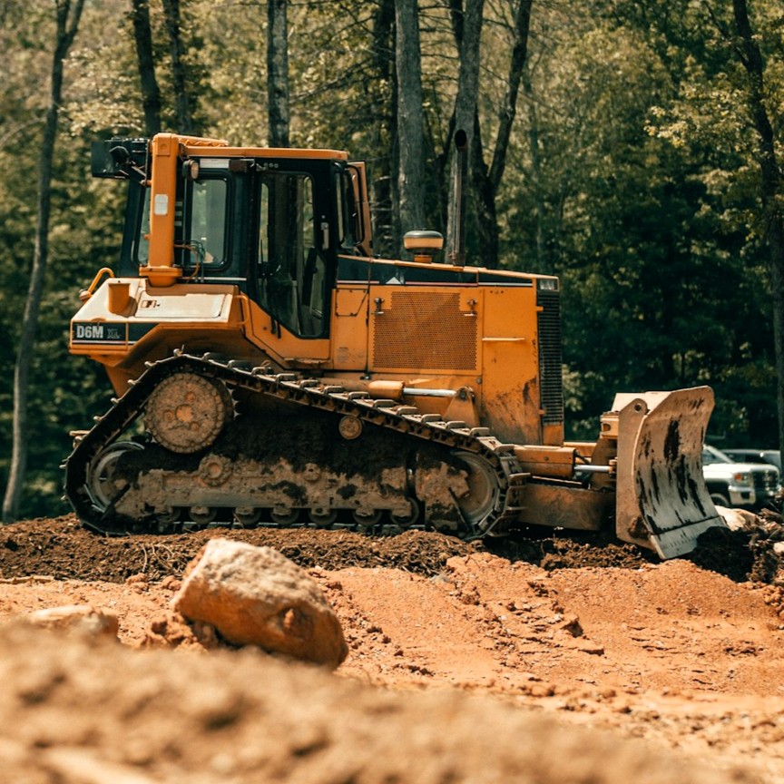Gelbe Planierraupe (Bulldozer) mit Planierbalken im Tiefbau Stockfoto Unsplash