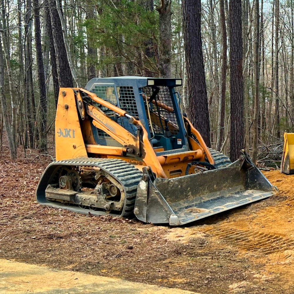 Kleiner gelber Kompaktlader mit Traktor im Tiefbau einer Baustelle im Wald Stockfoto Unsplash